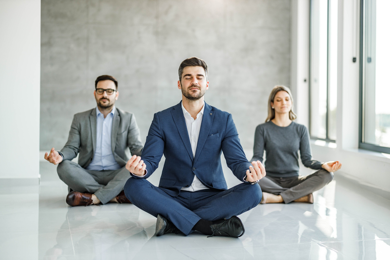 Relaxed business team exercising Yoga in the office.